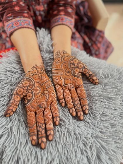 The full view of a beautiful bridal mehendi, perfect for a bride who loves detailed and full coverage. The patterns flow from the fingertips all the way to the wrist.