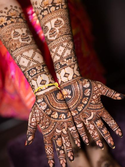 A close-up of the palms, featuring semi-circular mandalas with lotus and elephant details.
