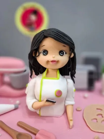 A close-up of the mini-me figurine on my anniversary cake. My team captured everything, right down to the phone in my hand!