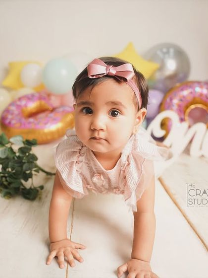 This little girl is on the move during her donut-themed first birthday shoot. Her curious expression is absolutely captivating.