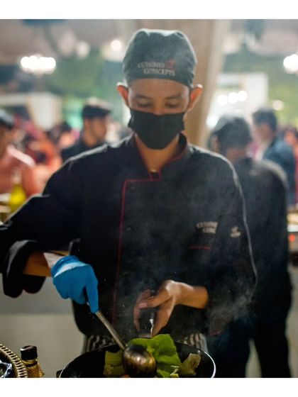 A chef at our "Dancing Wok" station prepares a vibrant Asian stir fry. The fresh, colourful vegetables and the chef's focused technique promise a dish that is both healthy and delicious.