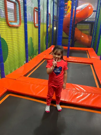 A girl enjoying a moment on the trampoline. It's a great way to build coordination and have fun in a safe, netted area.