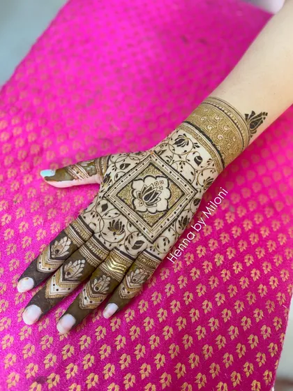 A simple yet striking design with a central square lotus motif on the back of the hand.