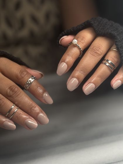 A beautiful, understated nude manicure on short, rounded nails. This soft, taupe-nude is the epitome of clean, chic, and classy.