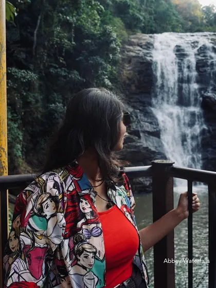 A woman looks at the beautiful Abbey Waterfalls in Coorg. It's a moment of peace and admiration for nature's power and beauty.