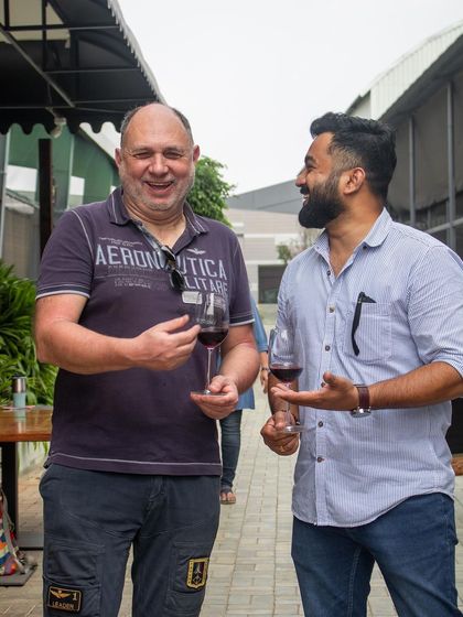 Guests mingling and enjoying a glass of red wine at our outdoor event.