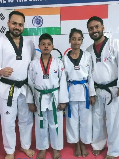 Two students with their coaches after their belt promotion. We foster a supportive environment with our senior and junior coaches.