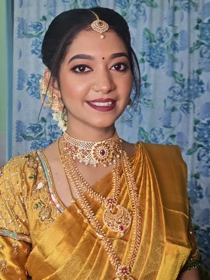 A close-up of a bride getting ready for her temple wedding. The makeup is traditional and elegant, with a focus on her eyes and lips.