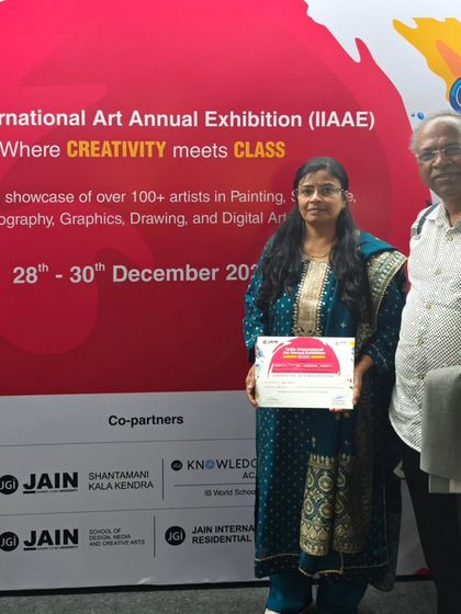 With my husband at the exhibition, holding my participation certificate. His support means the world to me.