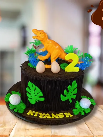 A roaring good time for a second birthday. This chocolate cake is designed to look like a tree stump, topped with a dinosaur, edible eggs, and jungle leaves.