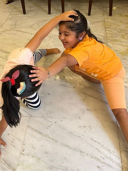 Two students working together to create a "car" shape with their bodies. Partner exercises are a great way to encourage collaboration and problem-solving.