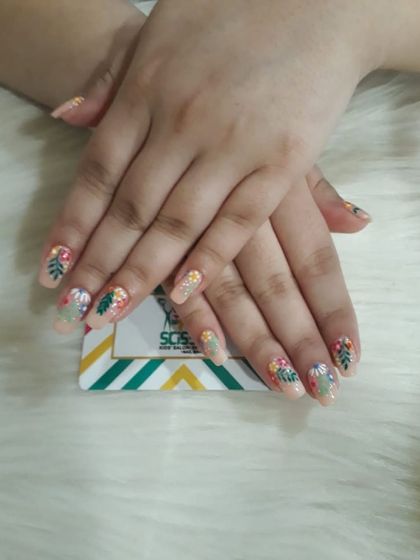 A tropical vibe with hand-painted leaves and flowers on a neutral base. This detailed botanical nail art is perfect for a vacation or just to bring some sunshine to your day.