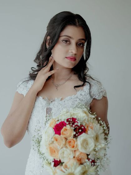 A beautiful portrait of the bride, holding her bouquet. Her serene expression and the delicate details of her dress are the focus of this shot.