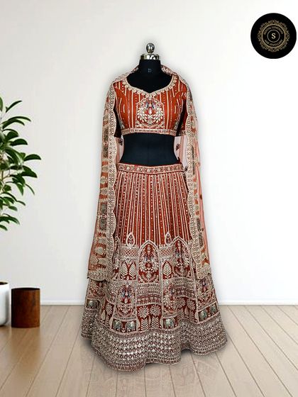 Another angle of the stunning rust-orange lehenga, showcasing the detailed craftsmanship on the skirt and blouse.