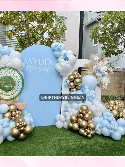 A different angle of the blue and gold setup, showing the teddy bear nestled in the balloons.