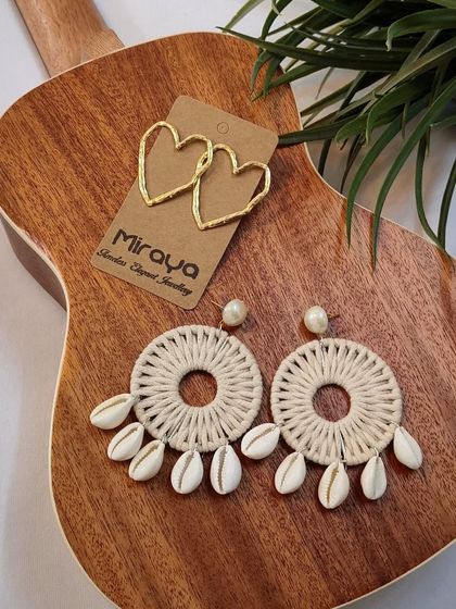 A styled shot of our seashell and heart-shaped earrings on a ukulele, capturing the perfect beachy, musical vibe.