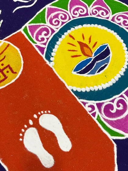 A close-up of the Lakshmi footprints and 'kalash' from a traditional rangoli. These symbols are central to Diwali celebrations, meant to invite prosperity and good fortune.