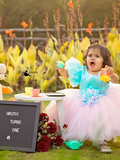 A roar of excitement for her first birthday! This little girl is having a blast at her outdoor tea party with her tiger friend.