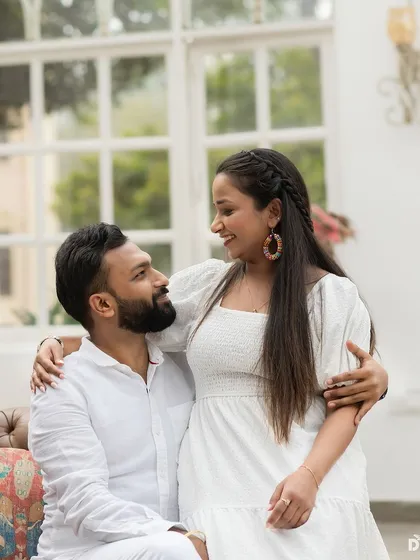 A close-up of the couple, showcasing her natural and glowing makeup. The braided hairstyle adds a touch of bohemian chic to the look.