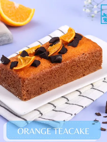 My Orange Teacake is a simple, nostalgic treat. This moist, eggless loaf cake has a bright citrus flavor from fresh oranges and is topped with chocolate chunks and dehydrated orange slices.