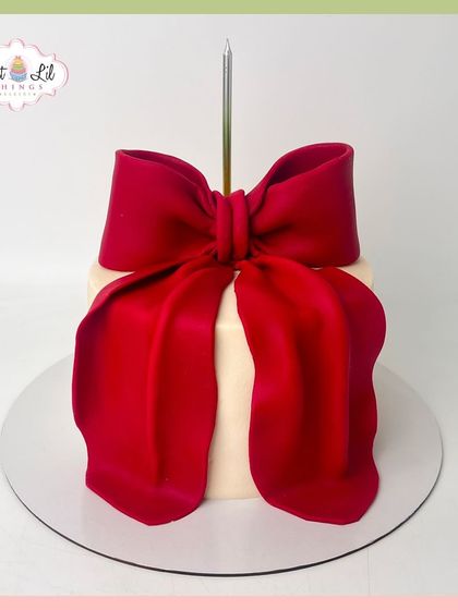 A simple and elegant gift-box cake, wrapped in a large, dramatic red fondant bow.