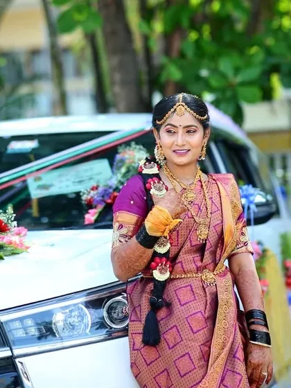 Posing by the wedding car, this bride is ready for her big entrance. Her traditional gold jewelry is perfectly complemented by the makeup.