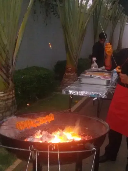 Nothing beats the aroma and flavor of food from a live tandoor. Our chef is seen here grilling succulent paneer tikka skewers over hot coals at an outdoor party. This service is perfect for adding a traditional and theatrical touch to weddings and social gatherings.