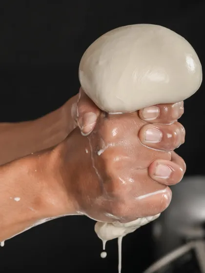 This is where the magic begins. Our cheesemakers hand-stretch fresh mozzarella curds, a crucial step that gives our cheese its signature soft texture and perfect melt. You can see and feel the quality that comes from a hands-on, traditional process.