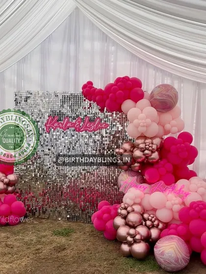 A beautiful pink and rose gold balloon arrangement against a silver shimmer wall. This setup is perfect for a glamorous and feminine celebration.