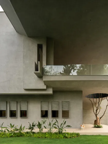 This New Delhi farmhouse, conceived as a private gallery, is a study in monumental forms. The design explores a subtle brutalism, using the raw tactility of concrete to create a powerful dialogue between the structure and the surrounding nature.