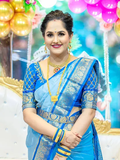 A front-facing portrait showing her radiant smile and the complete traditional look, including the kamarbandh and gold jewelry.