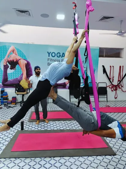 A closer look at the partner aerial pose, showing my hands-on guidance to ensure the flyer feels secure and the base maintains correct form.