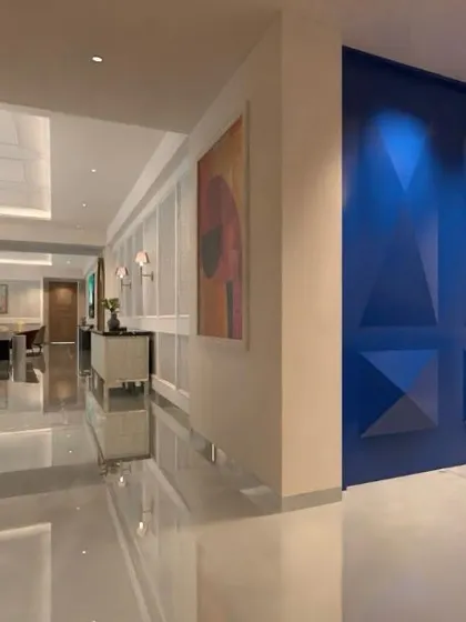 A striking blue geometric accent wall adds a pop of color and sculptural interest to this hallway. It serves as a piece of art in itself, transforming a simple passageway into a design moment.