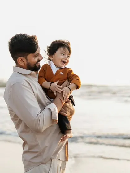 A father and son enjoying a moment at the beach. Outdoor sessions like this allow for natural movement and capture pure, unposed joy.