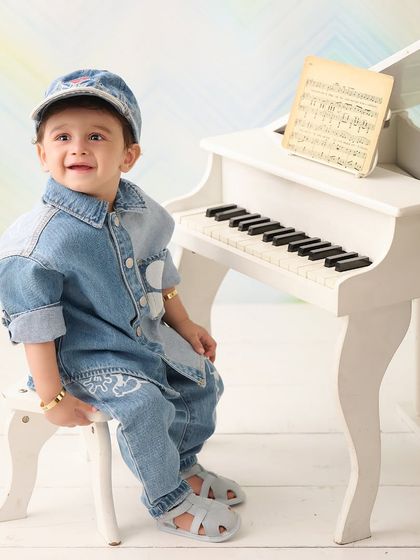 A mini musician at his piano. This little boy looks sharp in his denim outfit, ready to play a tune in this fun, musical-themed shoot.