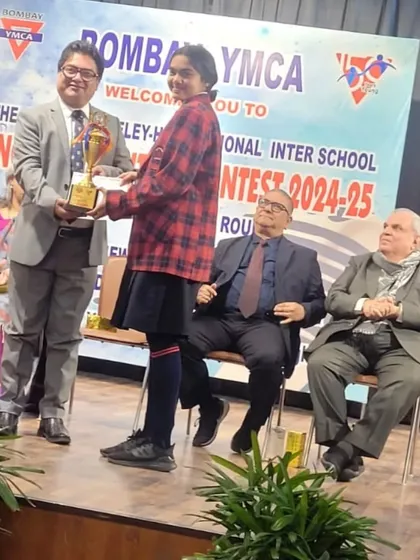 Lakshita receiving her trophy on stage for the elocution contest. We build well-rounded individuals.