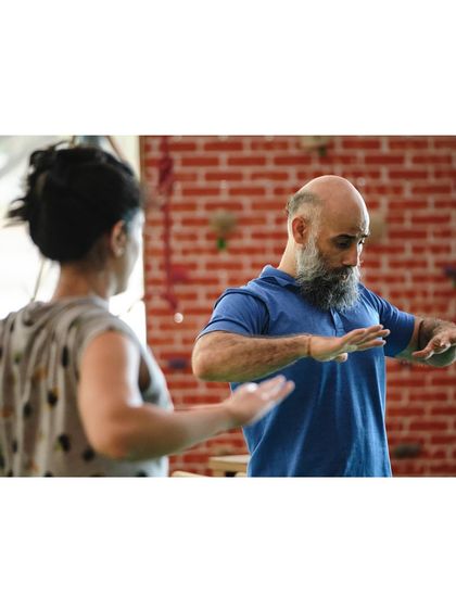 A moment of focused instruction, as our teacher explains the finer points of a movement to a student.