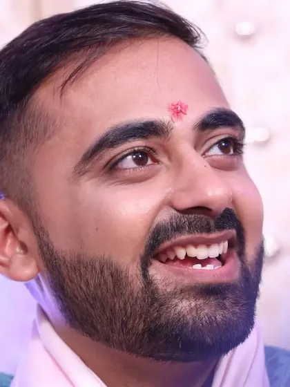 A candid, upward-looking shot of the groom. The makeup is flawless even in close-ups, ensuring a photo-ready finish.