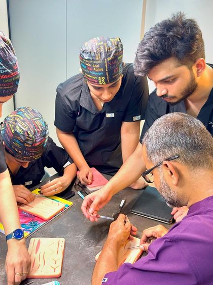 Dermatosurgery requires precision and practice. Here, our group is working on suturing techniques. This foundational skill is critical for ensuring minimal scarring and the best possible cosmetic outcomes for my patients after a procedure.