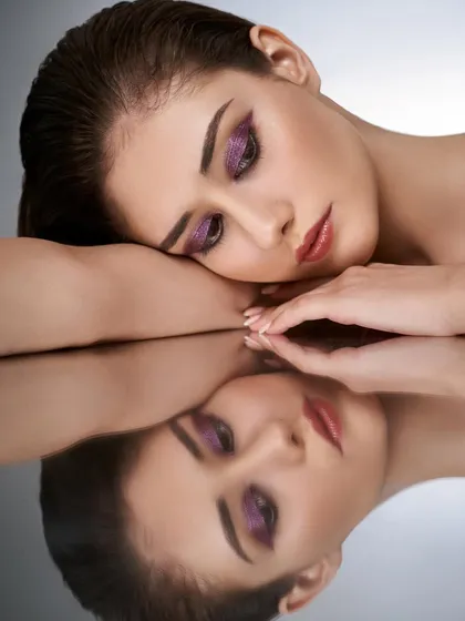 This beauty shot features a metallic purple winged eyeshadow, demonstrating my technical skill and creativity. The reflection adds an artistic touch, perfect for editorial or beauty-focused projects.