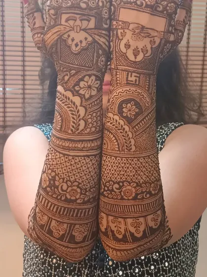 This full arm design incorporates various wedding symbols in bands, creating a rich tapestry of tradition for the bride.