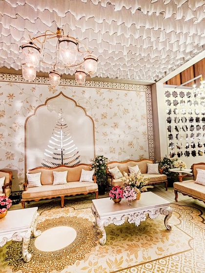 Another perspective of the grand lounge area, showing the large chandelier, the detailed wallpaper, and the elegant arrangement of sofas and coffee tables, creating a perfect space for conversation.