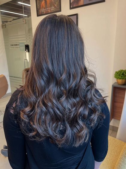 Cool-toned brown balayage on medium-length hair. The colors are blended to create a seamless transition from her natural base color.
