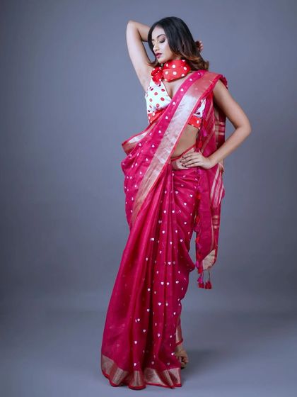 A bold and beautiful pink linen saree with white polka dots. This is a fun and playful piece, perfect for making a stylish statement while staying comfortable.