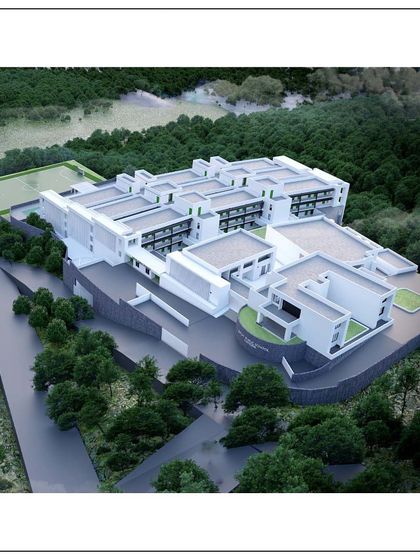 An aerial view of the school project in Kangra. The design consists of multiple interconnected blocks that create courtyards and open spaces, all nestled within a lush green landscape.