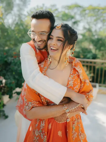 A moment of pure, uninhibited laughter. This candid shot captures the genuine joy and love between the couple during their Haldi ceremony.