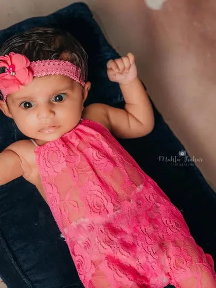 Wide-eyed and ready for fun! This portrait captures the baby's alert and curious expression during her beach-themed shoot.