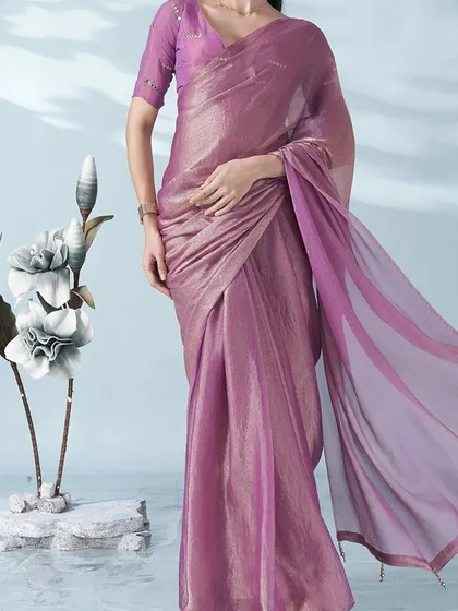 A beautiful lilac tissue saree that shimmers with a subtle golden sheen. This saree is lightweight, elegant, and perfect for a sophisticated look.