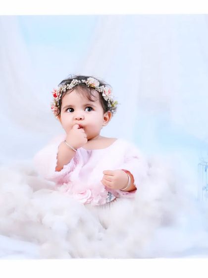 Like an angel in the clouds. This dreamy setup uses soft white tulle and a floral crown to create a heavenly portrait for this thoughtful baby girl.