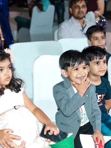 The kids' table, full of smiles and wonder as they watch the party entertainment. We capture the joy of friendship and shared experiences.
